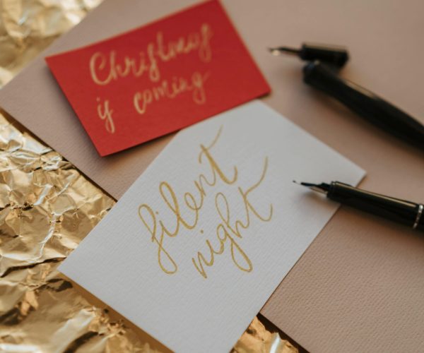 Festive greeting cards with elegant calligraphy on textured paper.