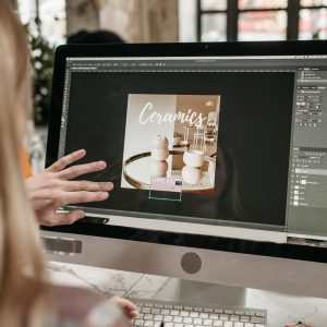 A graphic designer works on a ceramics promotion using Adobe Photoshop on an iMac.
