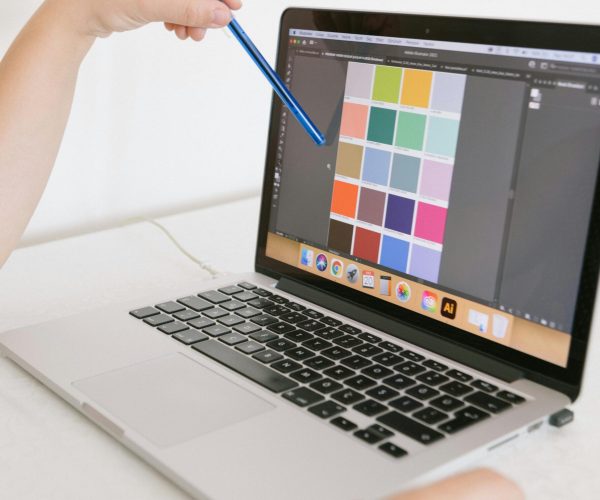 Close-up of hands using a laptop with a digital color palette, ideal for design work.
